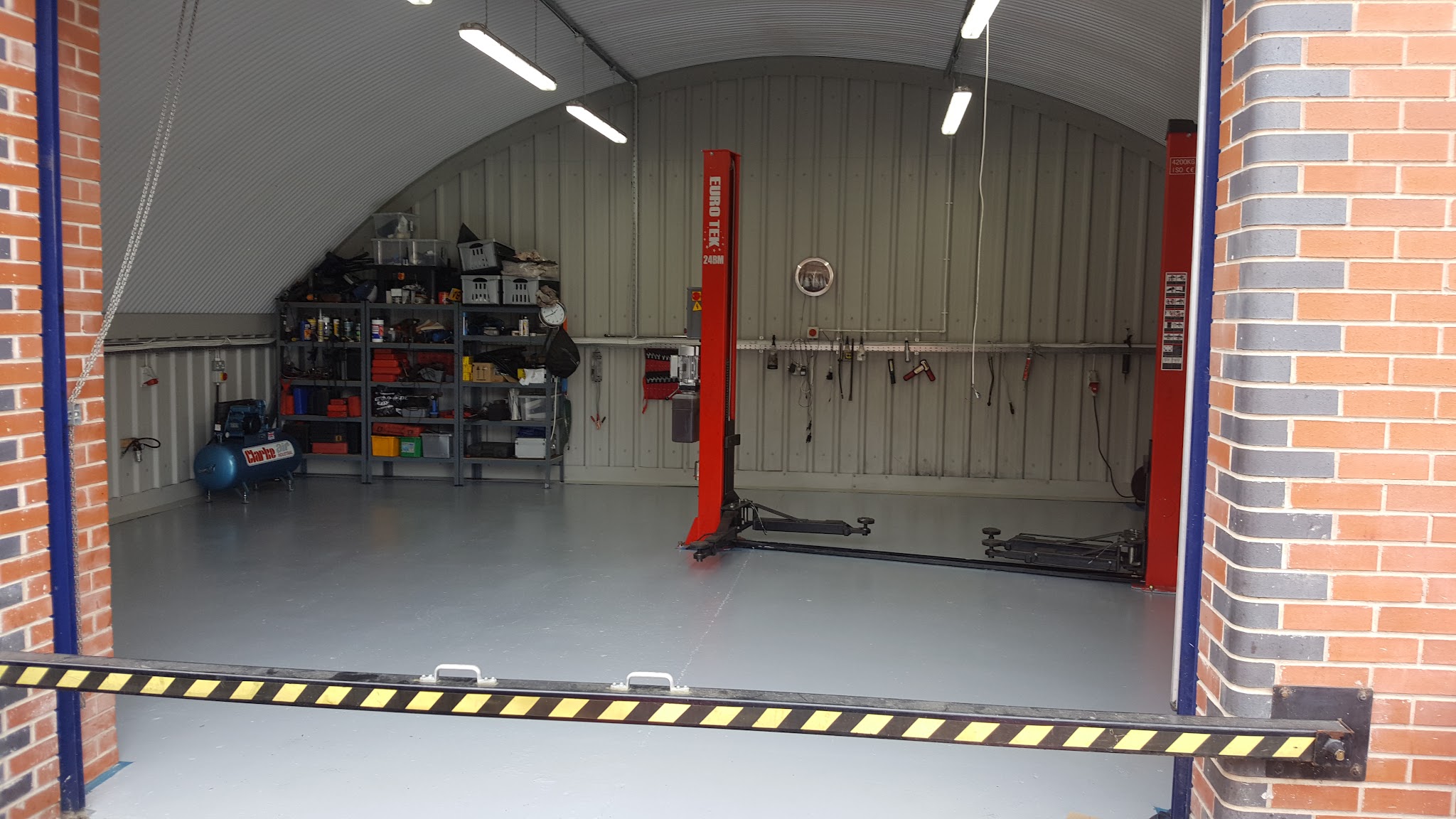 A clean workshop bay with a ramp and shelving