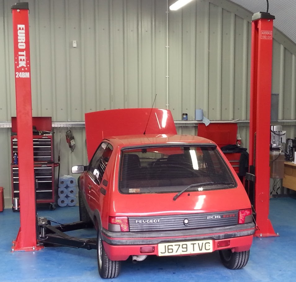 A red hatchback on the ramp with its bonnet up